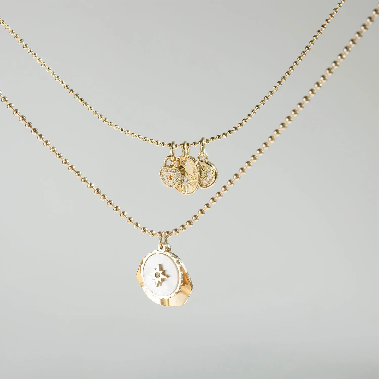 delicate chain with pearl coin compass and hammered gold charm